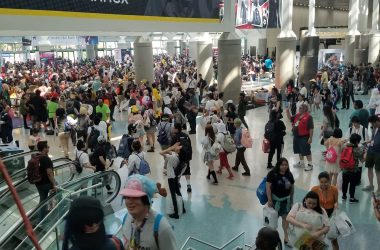 A large crowd at a convention center gathered beneath a banner for 'Kentia Hall,' indicating locations for Artist Alley, Autographs, and The Annex