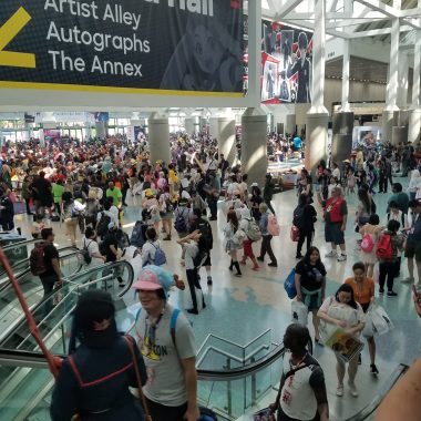 A large crowd at a convention center gathered beneath a banner for 'Kentia Hall,' indicating locations for Artist Alley, Autographs, and The Annex