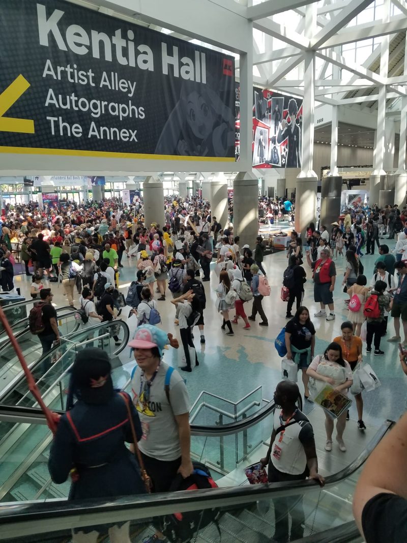 A large crowd at a convention center gathered beneath a banner for 'Kentia Hall,' indicating locations for Artist Alley, Autographs, and The Annex